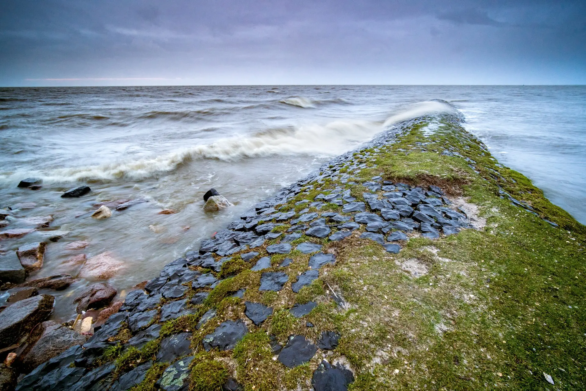 landscape sea surrounded by rocks covered mosses cloudy sky evening scaled